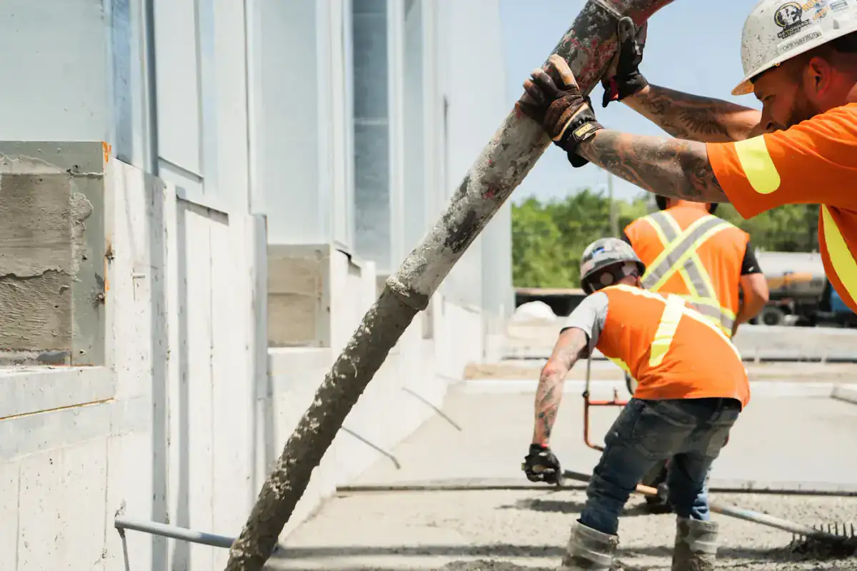 Crew guiding a concrete pump hose during a pour
