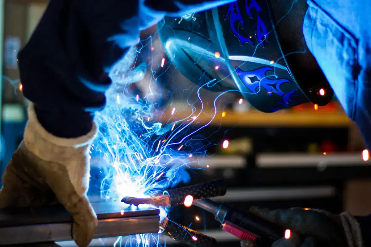 Welder working on metal with sparks