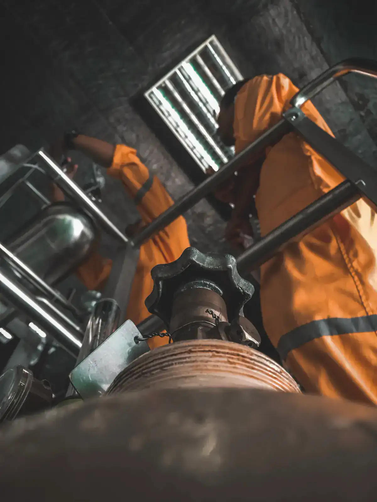 Crew in orange coveralls working on a plant valve