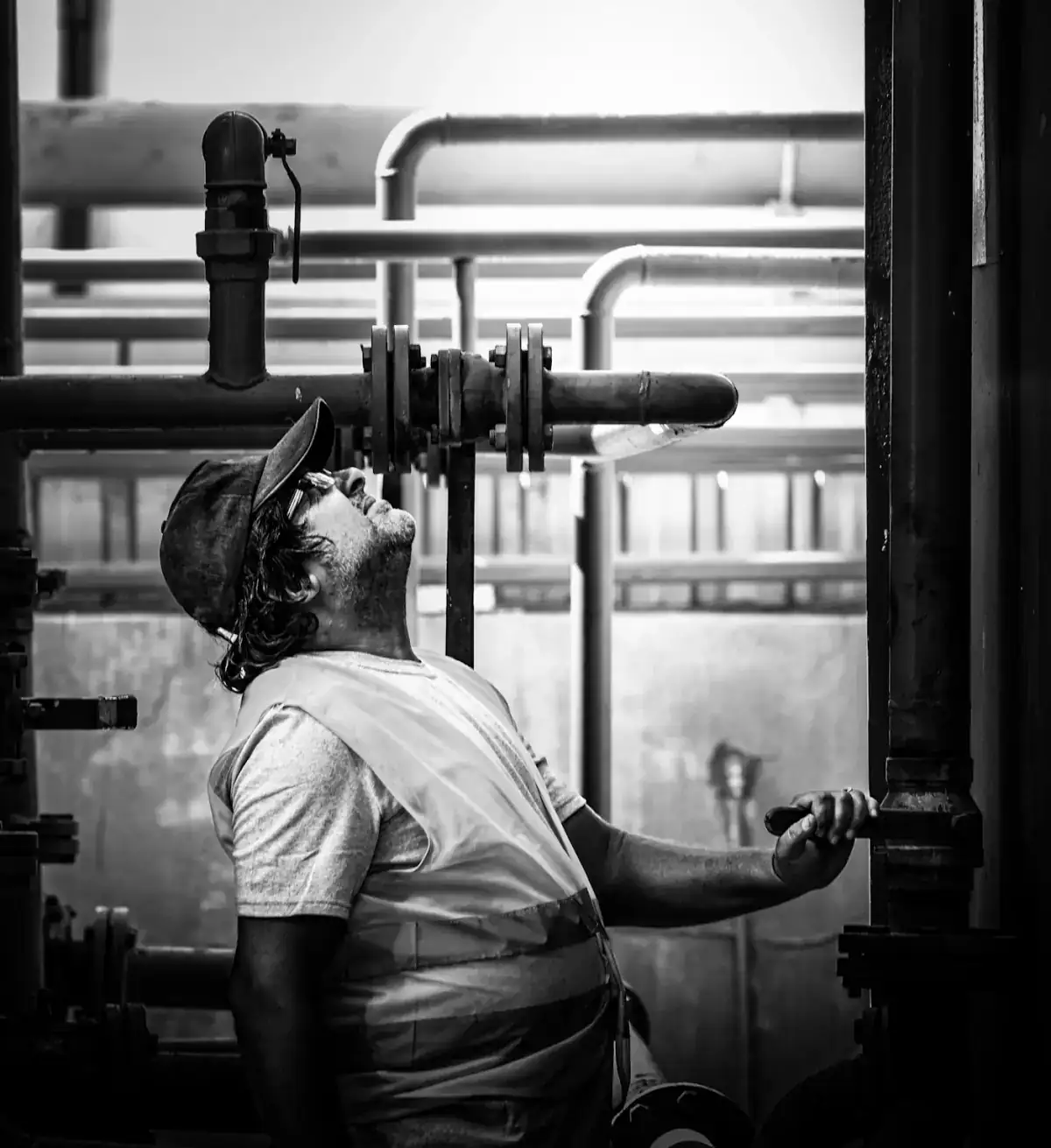 Plant worker inspecting pipes and valves
